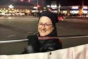 Eine Frau mit Brille lächelt in die Kamera