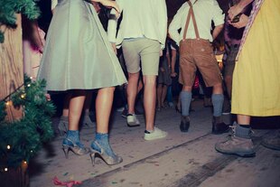 Menschen tanzen in Trachten und Turnschuhen