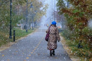 Eine Person in einem Mantel mit Leopardfellmuster läuft auf einer Straße