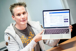 Jörg Ludwig, Gründer und Geschäftsführer der IServ GmbH, hält einen Laptop in den Händen, auf dem das Webportal von IServ angezeigt wird.