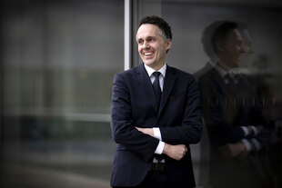 Lachender Mann mit verschränkten Armen