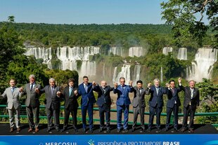 Politiker stehen vor einem Wasserfall