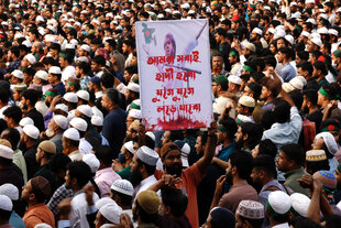Ein Mann, der in einer großen Menschenmenge steht, hält ein Schild mit der Aufschrift „Wir alle werden Hadi sein, wir werden weiterkämpfen“,