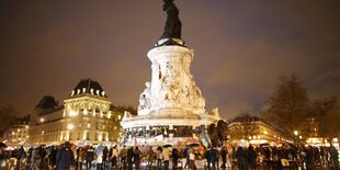 Auf dem Palce de la Republique legen Menschen Blumen für die Opfer der Anschläge hin