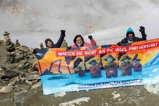 Aktivist:innen mit einem Transparent auf einem Berg