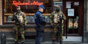 Soldaten und Polizisten stehen vor einem Restaurant