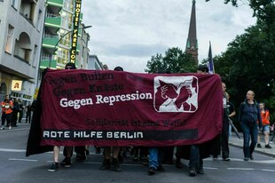 Demonstration mit Plakat der Roten Hilfe
