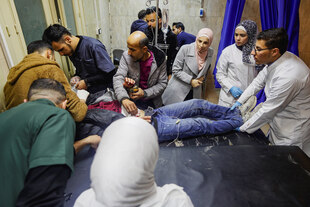 Mehrere Menschen versorgen in einem Krankenhaus einen Verletzten.