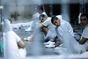 Häftlinge sitzen auf dem Boden