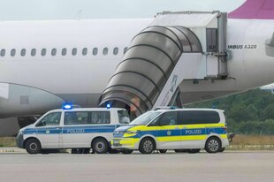 Polizeifahrzeuge an einem Linienflugzeug