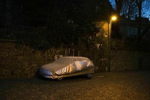Ein abgedecktes Auto steht in der Dunkelheit