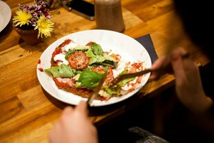 Ein Teller mit Tomaten und Basilikum.