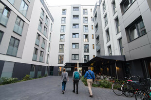 Drei junge Menschen in dem Innenhof eines Hauses