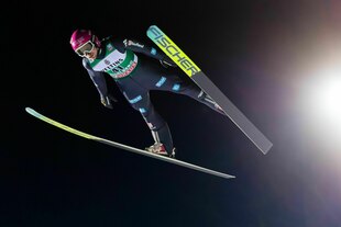 Skispringer Felix Hoffmann vor schwarzem Nachthimmel in der Luft