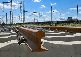 Ein neues Gleis, im Hintergrund Güterwaggons