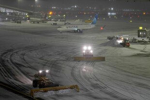Schneepflüge räumen das Vorfeld auf einem Flughafen