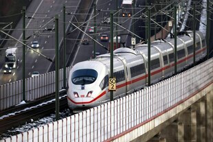 Ein ICE fährt über eine Brücke, eine Autobahn ist im Hintergrund zu sehen Ein ICE fährt über eine Brücke, eine Autobahn ist im Hintergrund zu sehen