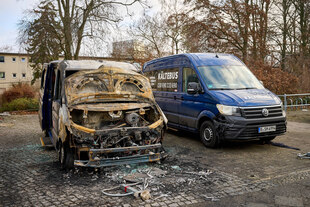 Ein abgebrannter Bus auf einem Parkplatz