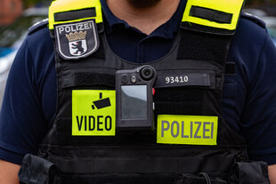 Ein Berliner Polizist trägt eine Bodycam an seiner Uniform
