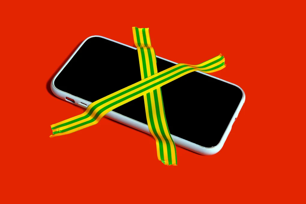 Ein Handy mit Tape auf roten Hintergrund geklebt