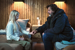 Der Kommissar sitzt auf einem Bett und redet mit einem Kind gegenüber Der Kommissar sitzt auf einem Bett und redet mit einem Kind gegenüber