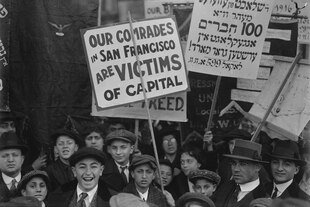 Menschengruppe, vor allem junge Männer, vereinzelt Frauen halten Schilder hoch: „Our comrades in San Francisco are victims“