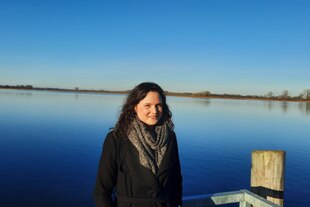 Eine Frau steht vor einer Seenlandschaft Eine Frau steht vor einer Seenlandschaft