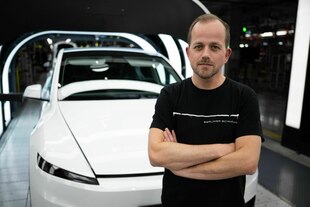 André Thierig, Werksleiter der Tesla Gigafactory Berlin-Brandenburg, steht mit verschränkten Armen in der Fabrik vor einem weißen Tesla-Auto André Thierig, Werksleiter der Tesla Gigafactory Berlin-Brandenburg, steht mit verschränkten Armen in der Fabrik vor einem weißen Tesla-Auto