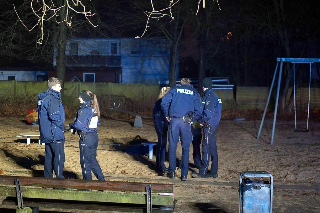 Polizist:innen stehen im Dunkeln auf einem Spielplatz