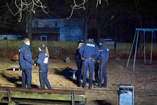 Polizist:innen stehen im Dunkeln auf einem Spielplatz