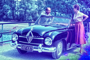 50er Jahre Idylle, ein Paar steht vor seinem Cabriolet - der Mann lächelt die Frau an, die an der Fahrerseite steht