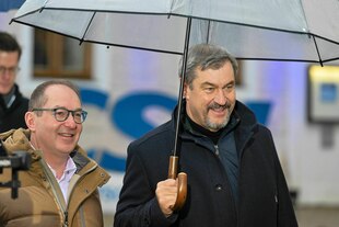 Alexander Dobrindt und Markus Söder unterm Regenschirm mit freundlichem Gesichtsausdruck