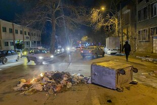 Nach einem Protest liegen Mülltonnen und brennender Müll auf einer Straße Nach einem Protest liegen Mülltonnen und brennender Müll auf einer Straße