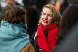 Ines Schwerdtner, mit rotem Schal, spricht mit einer Frau