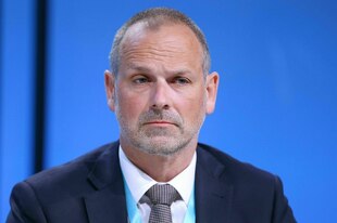 Ein Mann im Anzug schaut ernst in die Kamera