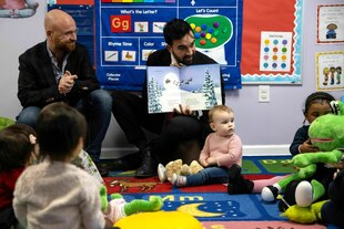 Zohran Mamdani besucht eine Kindertagesstätte und sitzt auf dem Boden und zeigt den Kindern ein Kinderbuch Zohran Mamdani besucht eine Kindertagesstätte und sitzt auf dem Boden und zeigt den Kindern ein Kinderbuch