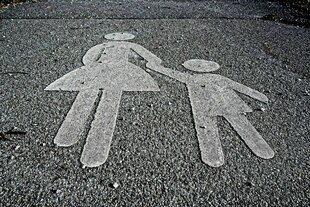 Das Symbol für einen Fussgängerweg zeigt eine Frau und ein Kind Das Symbol für einen Fussgängerweg zeigt eine Frau und ein Kind