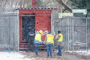 Einsatzkräfte stehen an der Brandstelle der Kabelbrücke vor dem Kraftwerk Berlin-Lichterfelde.