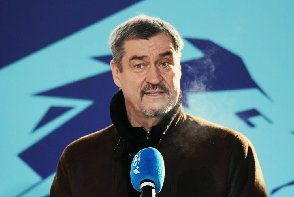 Markus Söder spricht an einem Wintertag, sein Atem bildet Rauchwolken