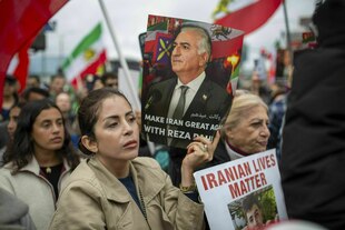 Bei einer Demonstration haten mehrere Personen Fahnen und ein Porträt von Reza Pahlavi hoch Bei einer Demonstration haten mehrere Personen Fahnen und ein Porträt von Reza Pahlavi hoch