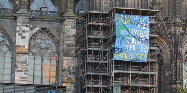 Ein Transparent hängt an einem Baugerüst am Kölner Dom.