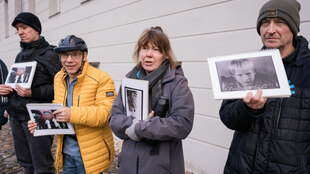 Mehrere Personen halten Bilder hoch