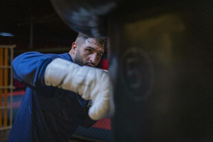 Agit Kabayel boxt mit der rechten Faust gegen einen Boxsack Agit Kabayel boxt mit der rechten Faust gegen einen Boxsack