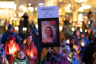 Menschen halten Kerzen und ein Foto von REnee Nicole Good in den Händen und demonstrieren
