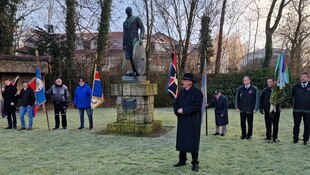 Leute stehen bei einem Denkmal