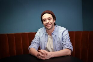 Mann mit roter Mütze sitzt an einem Tisch