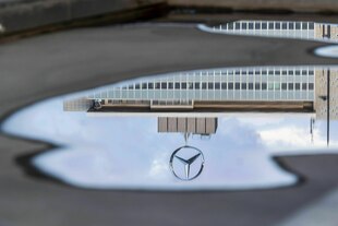 Ein Mercedesstern spiegelt sich in einer Wasserpfütze Ein Mercedesstern spiegelt sich in einer Wasserpfütze