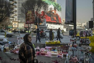 Straßenszene vor einem riesigen Propagandaplakat in Teheran