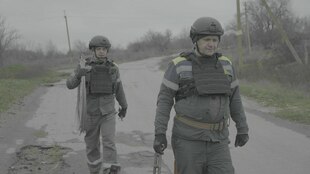 Zwei Personen mit Schutzausrüstung und mit Kabeln bei der Arbeit Zwei Personen mit Schutzausrüstung und mit Kabeln bei der Arbeit