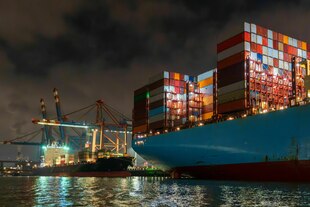 Ein mit Containern beladenes Frachtschiff bei Nacht Ein mit Containern beladenes Frachtschiff bei Nacht